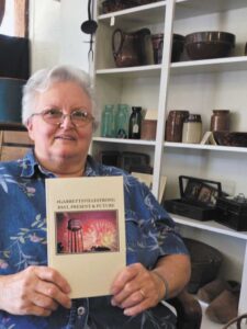 Pam Montgomery holding a copy of her book entitled #GarrettsvilleStrong 