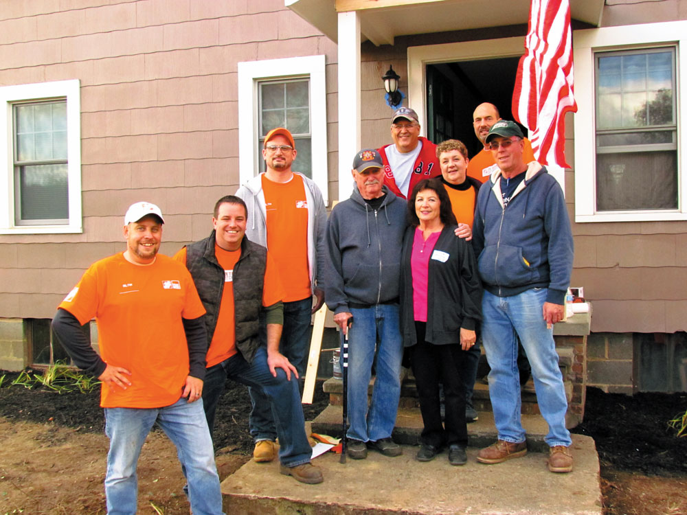 Team Depot -- Home Depot Volunteers including District Manager Jeff Miller, Team Depot District Captain Chris Schigel, Merchandise Manager Paul (with wife Hillary) Onuska, and Store Manager Jason Eidam, along with local volunteers Ronnie Kotkowski and Linda Elhert, surround local veteran Bud Foster.
