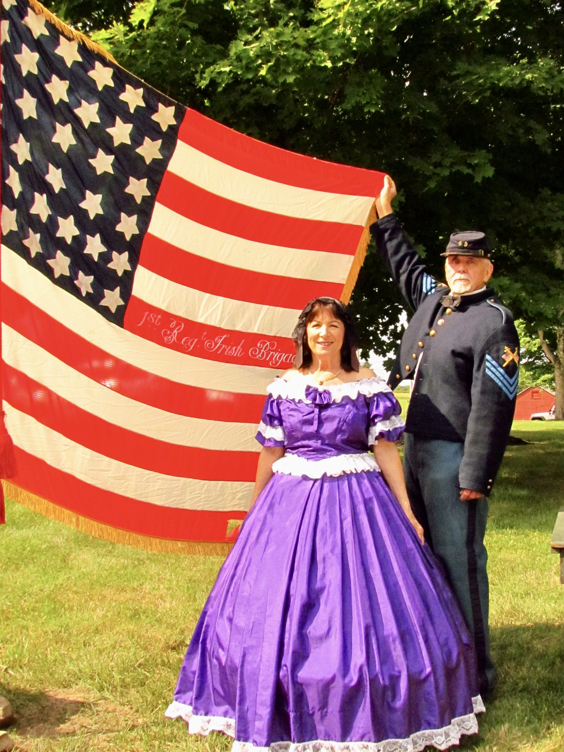 man and woman in civial war outfits with american flag