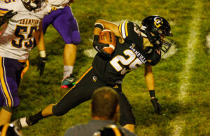 Garfield Football Runs Rampant Against Champion Garfield freshman Nathan Baczkowski slips through Champion’s defense, picking up a nearly 20 yard gain early in the second half of the September 15th game. Photo: Benjamin Coll/JAG Schools