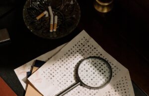 A Pep Rally To Die For: Murder Mystery Fundraiser Planned for the Nelson Garrettsville Community Cupboard photo of cryptic character codes and magnifying glass on table top