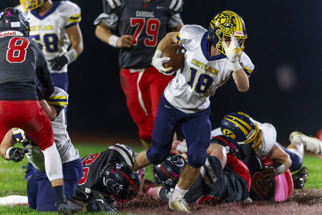 Kirtland #18 Will Beers runs up the middle with Cardinal #28 Nell Lucariello making shoestring tackle