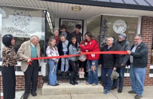 Lifelong Ravenna friends realize dream of owning a hair salon Sara Davis (right center) and Morgan Taylor (left center) proudly cut the ribbon to commemorate the grand opening of Rooted & Co Salon/Photo by Daniel Sherriff
