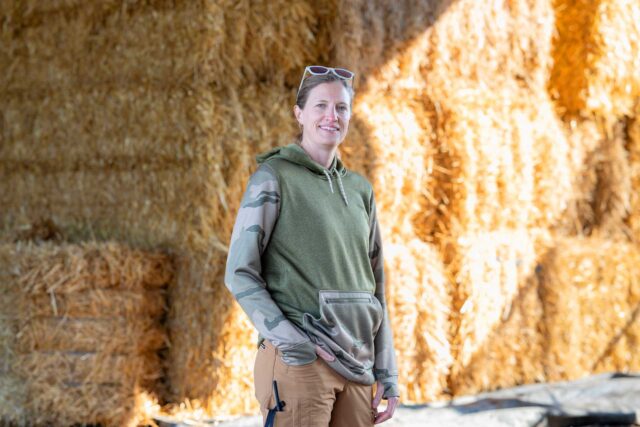 Windham graduate Colleen Thompson stands in front of hay at the family farm